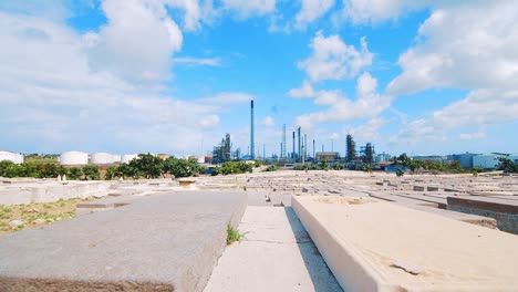 Reveal-shot-of-an-empty-cemetery-with-a-large-industrial-refinery-in-the-background-in-Curacao