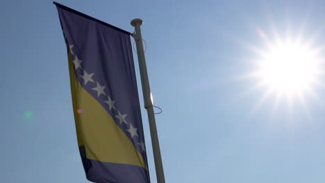 Zeitlupenvideo-Der-Bosnischen-Und-Herzegowinischen-Flagge,-Die-An-Einem-Sonnigen-Tag-Im-Wind-Weht