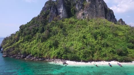 Außergewöhnliche-Luftaufnahme-Von-Traditionellen-Thailändischen-Booten-Am-Ufer-Eines-Privatstrandes-Auf-Einer-Bergigen-Exotischen-Insel