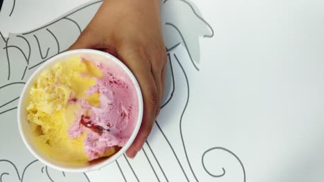 Close-up-taking-scoops-of-multi-coloured-Ice-cream-to-eat-from-tub