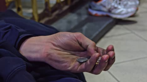 Homeless-holds-coins-tight-grateful-for-support,-close-up