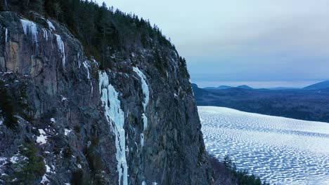 Aerial-footage-rising-up-along-a-giant-mass-of-icicles-known-as-Maineline-on-a-tall-steep-cliff-in-Maine