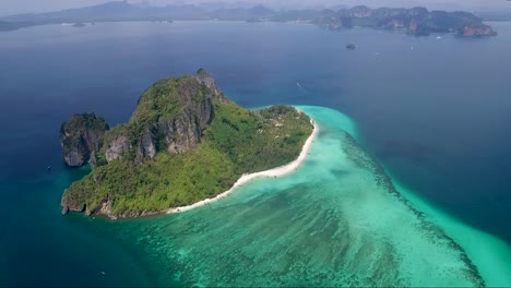 Luftaufnahme-Einer-Kleinen-Tropischen-Insel,-Umgeben-Von-Einem-Riesigen,-Farbenfrohen-Ozean