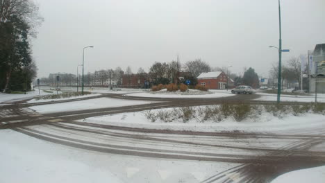 A-roundabout-in-a-snowy-winter-with-careful-driving-traffic