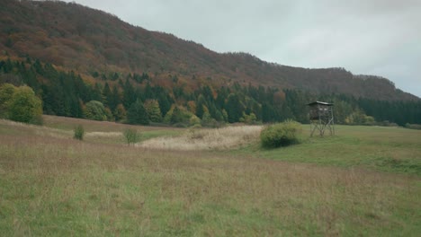 Jagdhütte-Auf-Einem-Feld,-Umgeben-Von-Bergen-Und-Wäldern