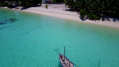 Pequeña-Playa-Privada-Con-Un-Barco-De-Pesca-Solitario-En-Aguas-Poco-Profundas-Y-Claras-De-Maldivas