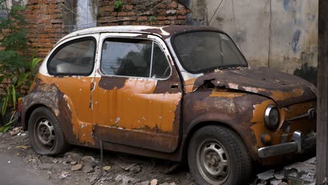 Coche-Viejo,-Fiat-500,-Bangkok,-Tailandia-Quemado-Destrozado-Abandonado-Junto-A-La-Pared-De-Ladrillo