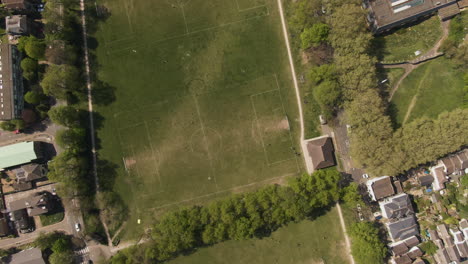 Grüne-Lokale-Fußballhöfe-Mit-Weißen-Linien-In-Der-Kleinstadt,-Luftaufnahme-Von-Oben-Nach-Unten
