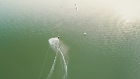 Drone-shot-of-a-person-wake-boarding-on-the-lake-Zlate-Piesky,-Bratislava,-Slovakia