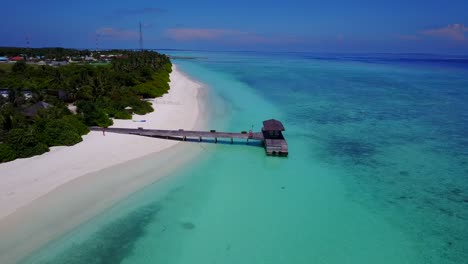 Panoramic-aerial-orbit-around-lone-dock-alongside-Maldives-coast-with-beautiful-white-beach-on-crystal-clear-water