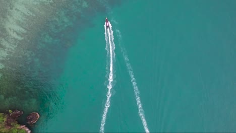 Spannende-Luftaufnahme-Von-Booten,-Die-Durch-Das-Türkisfarbene-Wasser-Thailands-Rasen