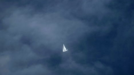 Velero-Navegando-En-El-Océano-Azul-Bajo-Una-Fina-Capa-De-Nubes-Antena
