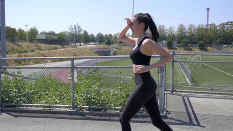 Beautiful-Sporty-Girl-Jogging-Outdoors,-Side-View-Tracking-Shot-SLOMO