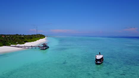 Mann,-Der-Auf-Dem-Tourboot-Steht,-Während-Es-Zum-Hafen-Auf-Der-Schönen-Malediveninsel-Fährt