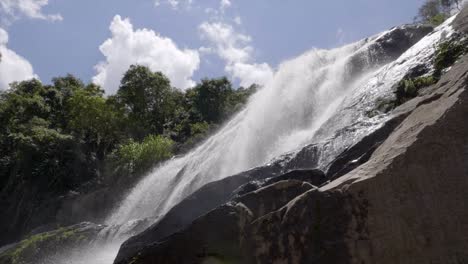 Slow-motion-cascading-waters-running-off-rocky-terrain-waterfall-viewed-from-below