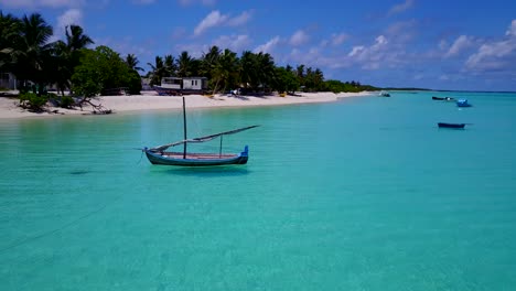 Barco-Dhoni-De-Maldivas-Flotando-En-Aguas-Cristalinas-En-El-Océano-índico,-Pan-4k