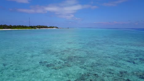 Blick-Vom-Kristallblauen-Wasser-Auf-Eine-Tropische-Insel,-Die-Mit-Palmen-Bedeckt-Und-Von-Staubigen-Weißen-Stränden-Umgeben-Ist