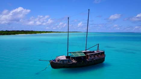 Wooden-boat-anchored-in-crystal-clear-turquoise-waters-in-Maldives-lagoon