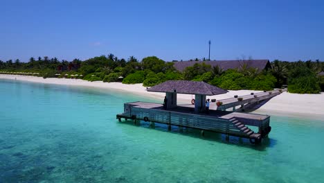 Mann-Wartet-Auf-Boot-Auf-Malediven-Holzsteg,-Luftpfanne-Um-Ruhiges-Meer-4k