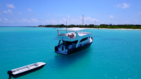 circular-aerial-move-around-a-touristic-boat-anchored-at-the-shores-of-a-tropical-island