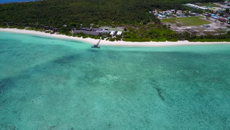 Wide-aerial-establishing-shot-of-pristine-Maldive-ocean,-resort-and-island-village