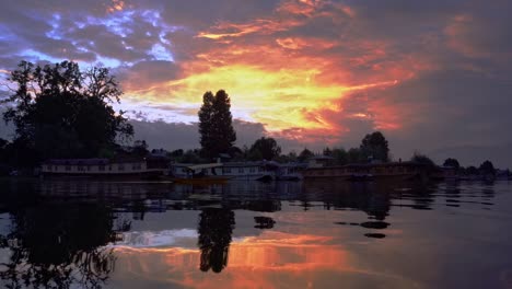 Scenic-View-Of-Large-Floating-Houseboats-In-Idyllic-Lake-Over-Dramatic-Sunset-Sky