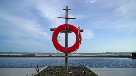 lifebuoy-ring-near-swimming-pool-with-sea-background