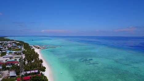 Hanimaadhoo-reveal-shot,-aerial-descent-towards-beautiful-island-village-4k