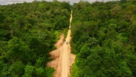 A-pick-up-truck-drives-along-a-dirt-trail-in-the-Amazon-Rainforest