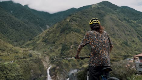 Biker-Mit-Blick-Auf-Die-Wasserfälle-Während-Der-Radtour-In-Baños-Ecuador