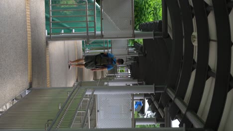 vertical-video-:-Chinese-man-walking-away-on-a-covered-walkway