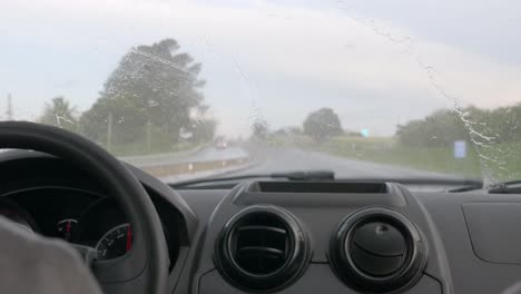 Rainfall-hitting-windshield-view-from-interior-of-vehicle