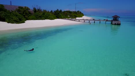Hombre-Nadando-De-Espaldas-En-El-Agua-Turquesa-Del-Mar-Caribe,-Imágenes-De-Drones-Con-Cielos-Despejados