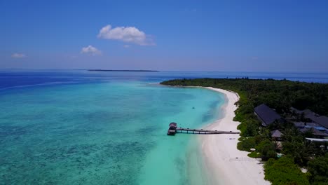 Ein-Blick-Auf-Ein-Resorthotel-Und-Seine-Holzterrasse-Auf-Dem-Türkisfarbenen-Meer-Auf-Den-Malediven,-Horizontale-Ansicht-Von-Drohnenaufnahmen
