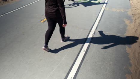 Woman-in-black-taking-a-stroll-on-the-cycle-lane-of-the-beach-of-Santa-Monica-beach