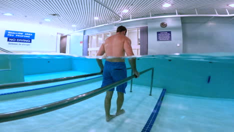 Man-walking-physiotherapy-in-pool