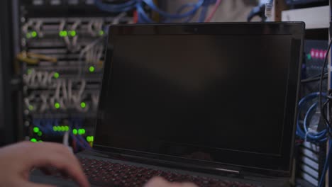 Hand-Opens-Laptop-Computer-Against-Blurry-Server-System-Background