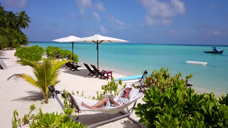 Escena-Tropical-De-Maldivas,-Retírese-Revelando-A-Una-Mujer-Hermosa-Relajándose-En-Una-Hamaca-De-Playa-En-Un-Resort-Aislado,-4k