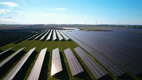 Cinematic-drone-shot-of-large-solar-panel-farm-lighting-by-sun-during-summer-day