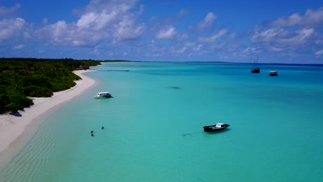 Luftaufnahme-Des-Türkisfarbenen-Strandes-Einer-Karibischen-Insel,-Während-Kleine-Boote-In-Seichten-Gewässern-Am-Meer-Schwimmen