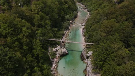 Eine-Schöne-Drohnenaufnahme-Des-Flusses-Soča-Mit-Einer-Brücke