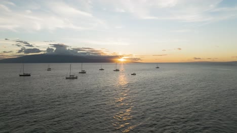 Lanai-Island-sunset-view-from-Lahaina-beach,-aerial-backward-from-anchored-boats