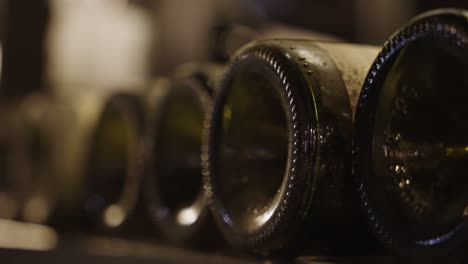 Close-up-of-the-bottom-of-5-bottles-of-vintage-wine-caked-in-dust-from-the-long-process-of-maturing