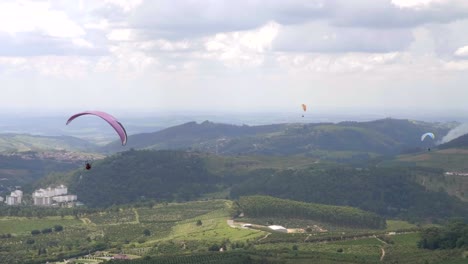 Group-of-para-gliders-following-valley-into-distance