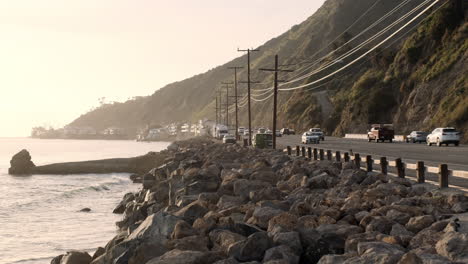 Rocky-shoreline-of-the-Big-Rock-beach-of-Malibu-next-to-a-edge-highway-at-golden-hour