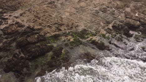 Luftaufnahme-Eines-Surfers-Auf-Den-Felsen-An-Der-Küste-Von-Punta-Del-Este-In-Uruguay