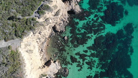Aerial-view-of-beautiful-clear-turquoise-water-and-rocky-cliff