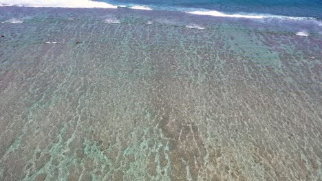 Vista-Aérea-Sobre-Arrecifes-Bajo-El-Agua-Turquesa-En-La-Isla-De-La-Reunión-Con-Olas-Muriendo-En-La-Parte-Superior
