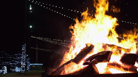 Slow-motion-pull-out-clip-of-a-large-bonfire-burning-brightly-at-night