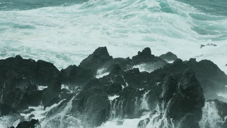 Dramatic-close-up-of-waves-crashing-over-rocks